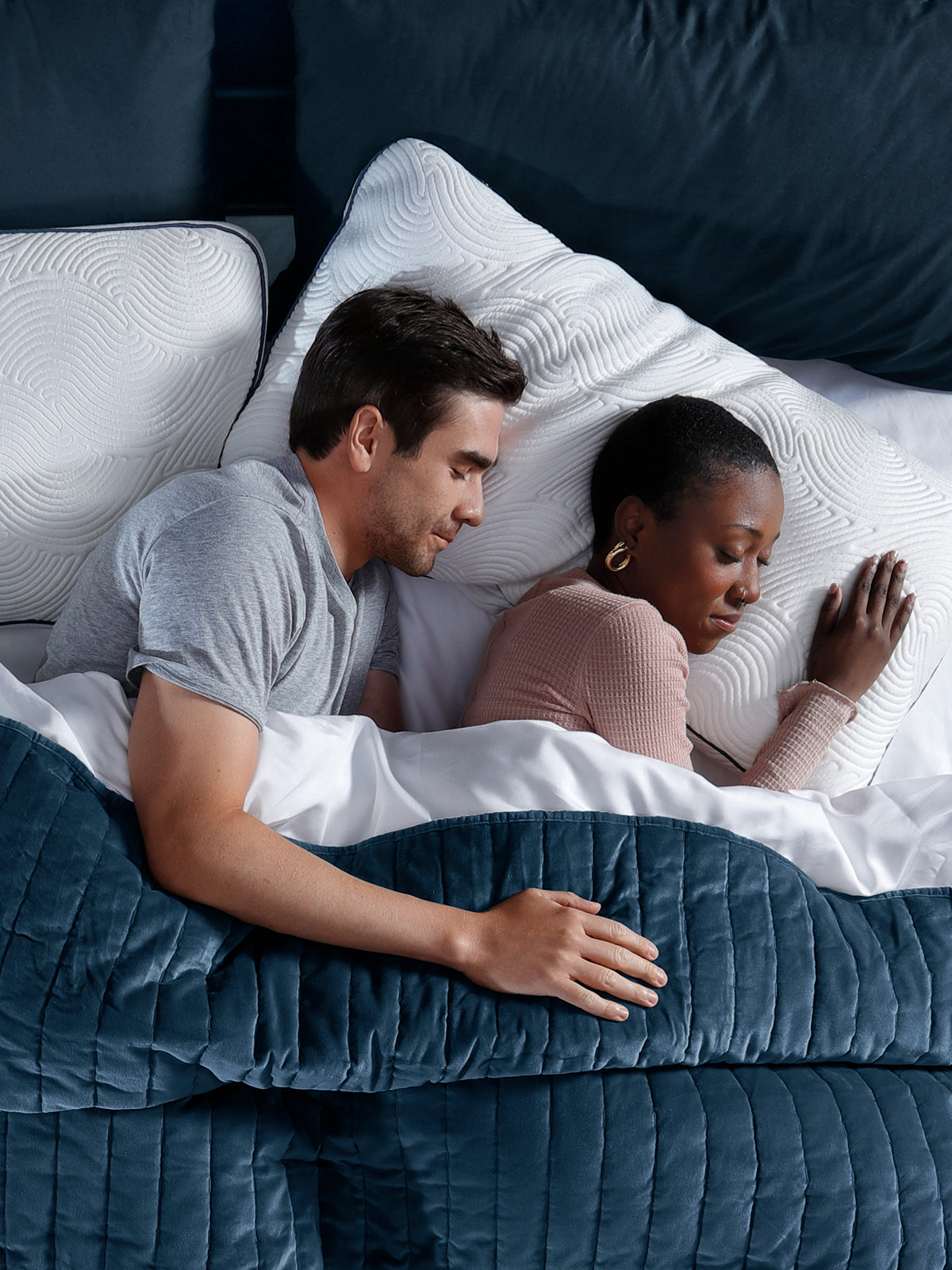 Diverse couple sleeping in dark room on luxury Parallel Pillows