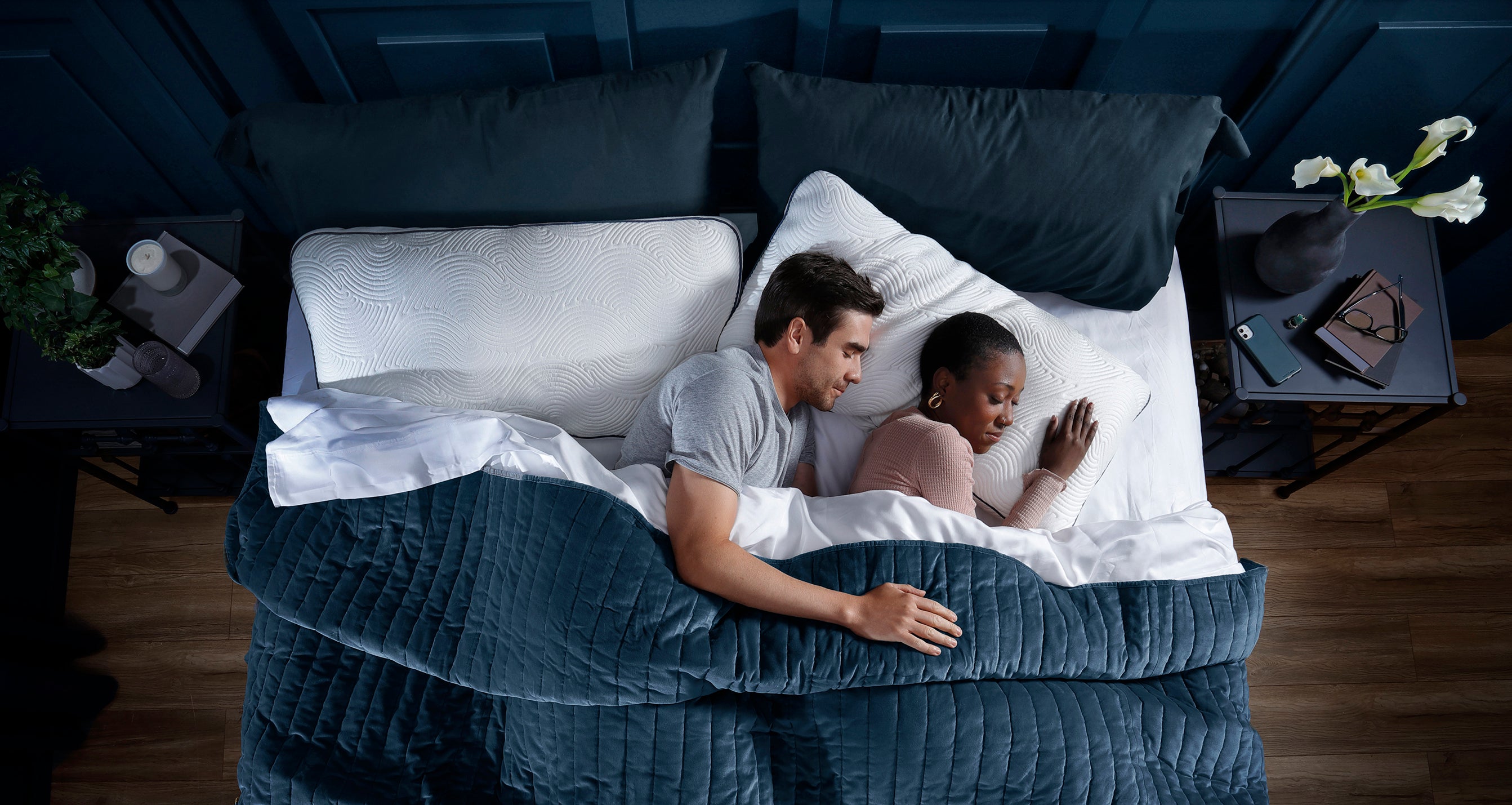 Diverse couple sleeping in dark room on luxury Parallel Pillows